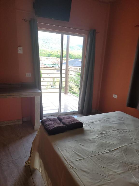 ein Bett in einem Zimmer mit einem großen Fenster in der Unterkunft Riverside Inn in El Dorado