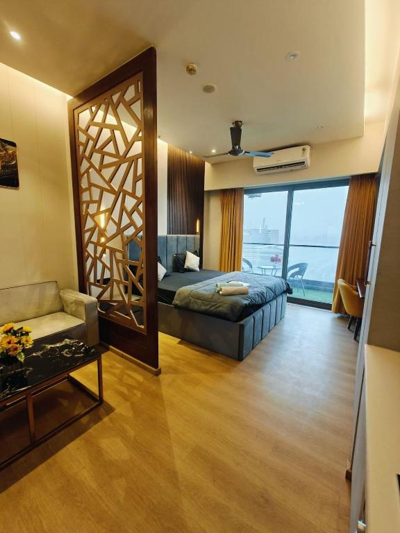 a bedroom with a bed and a living room at KakoonStudios Balcony Bliss in Ghaziabad