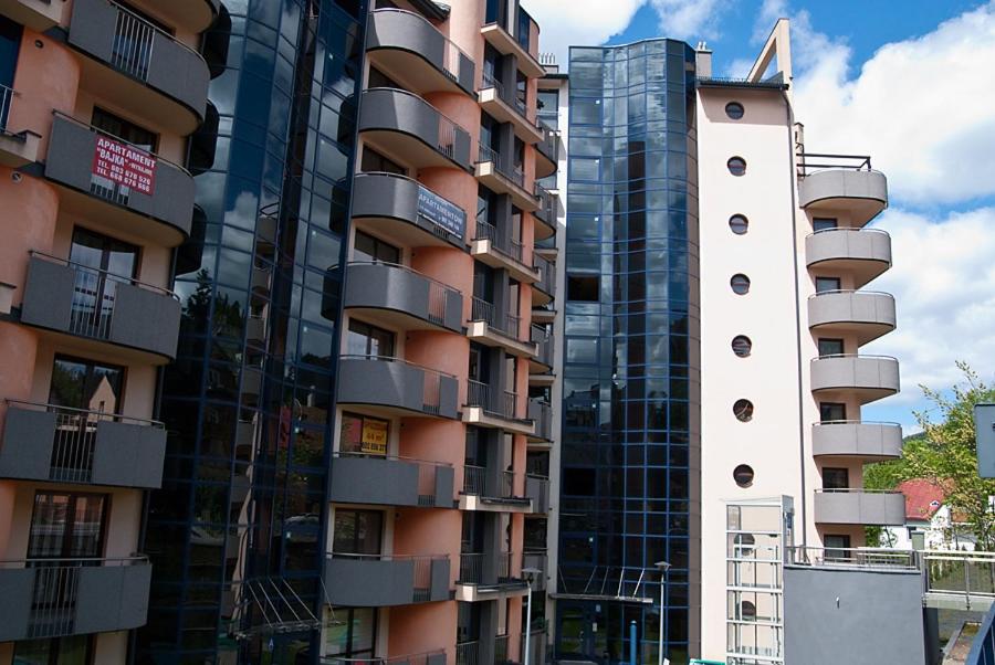 a tall building with a clock tower next to it at Apartament Perłowy in Krynica Zdrój