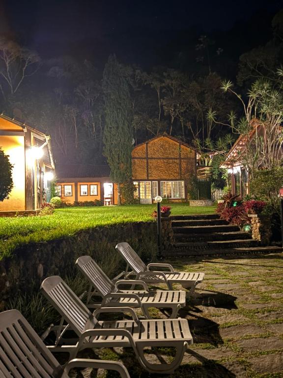 a row of chairs sitting in a yard at night at Casa do Fachoalto in Petrópolis