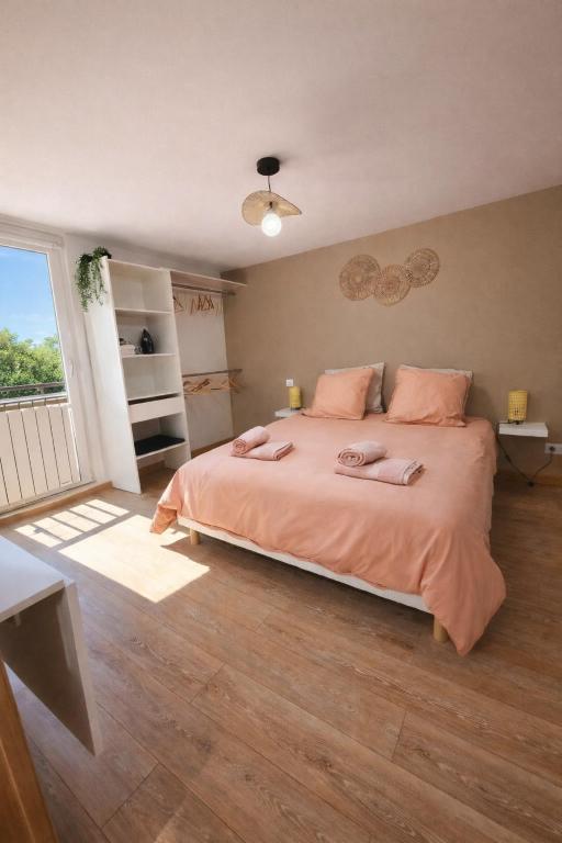 a bedroom with a large bed with pink pillows at Gîte d'Epona in Pierrefitte-en-Auge