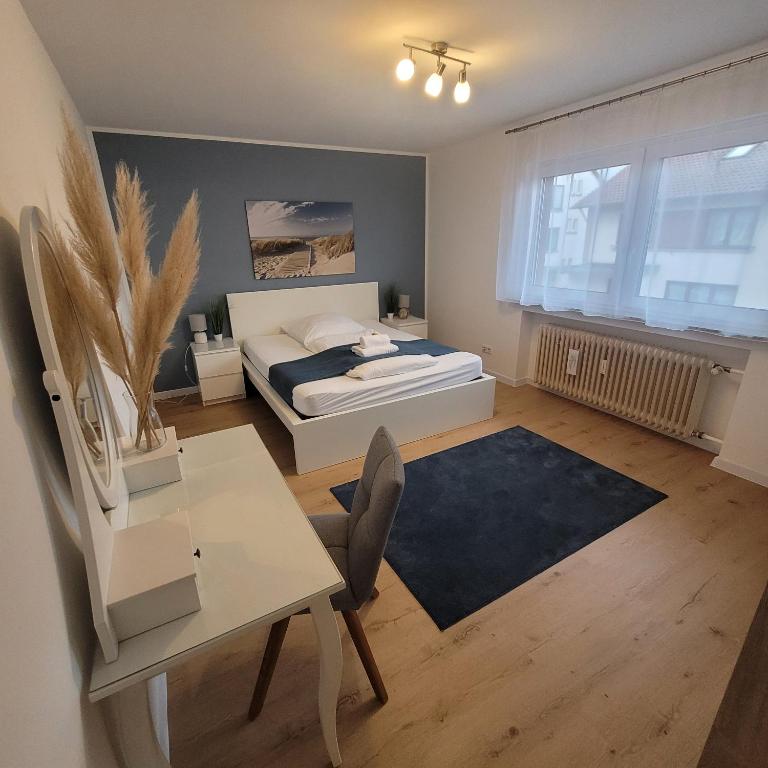 a bedroom with a bed and a desk and a table at Große,Schöne FeWo nähe Schwetzingen-Hockenheim 3 Zimmer mit Balkon in Oftersheim