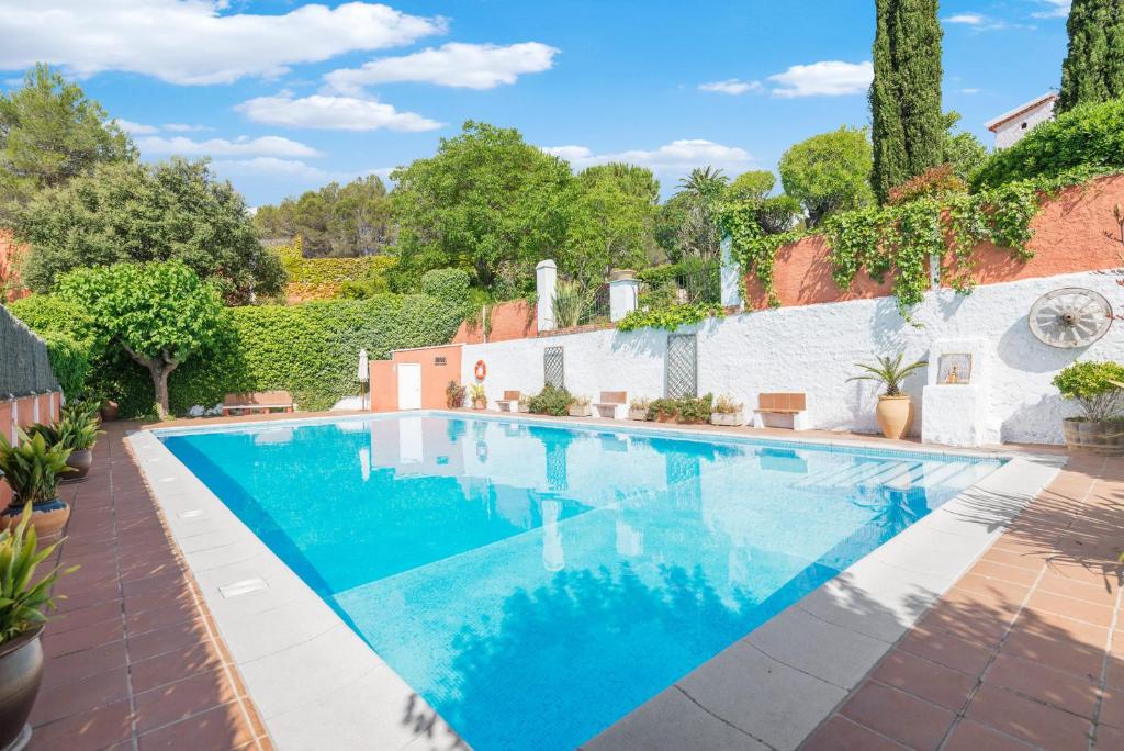 una piscina de agua azul en un patio en Comarquinal Bioresort Penedes, en Sant Quintí de Mediona