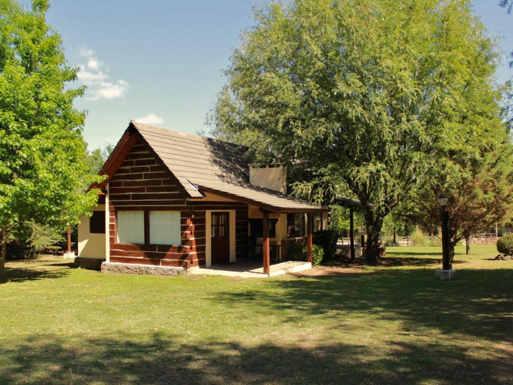a small log cabin with trees in front of it at Cabañas Los Maderos in Villa General Belgrano