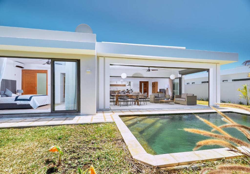 une villa avec une piscine et une chambre dans l'établissement Corail Bleu Private Villas by LOV, à Bain Boeuf