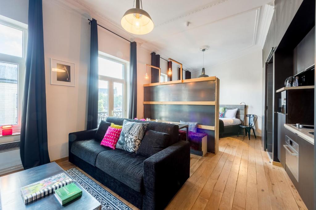 sala de estar con sofá negro y mesa en Smartflats - Sablon Brussels, en Bruselas