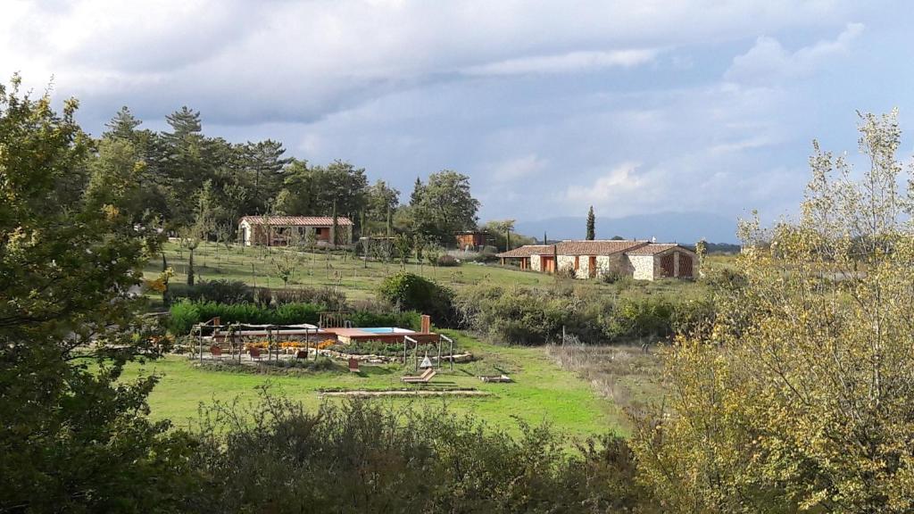 a farm in a field with buildings in the background at Agricampeggio Madonna di Pogi in Bucine