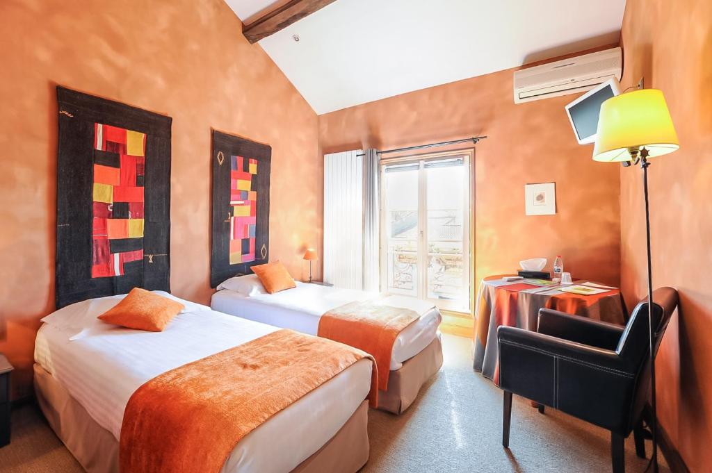 a hotel room with two beds and a window at Logis hotels Les Glycines in Melle