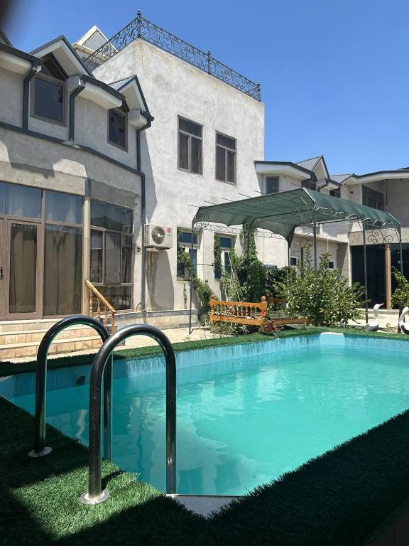 a swimming pool in front of a building at Home Villa YaaxYa in Bukhara