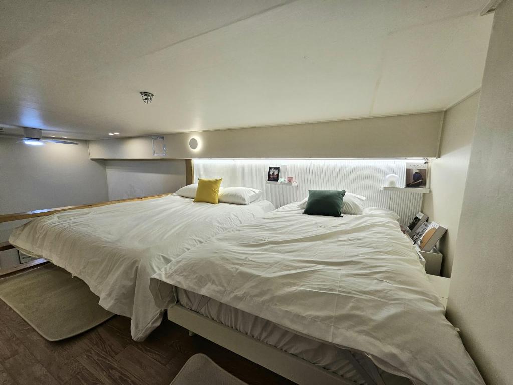 a bedroom with a large white bed with two pillows at 샤인 스테이 in Kung-mal
