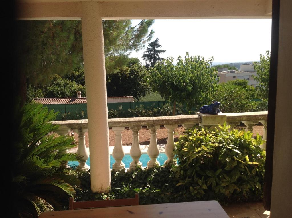 a person sitting on a fence next to a swimming pool at La Nectarine in Nice