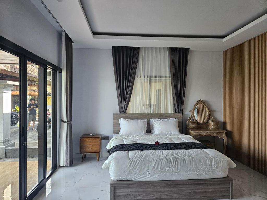 a bedroom with a large bed and a window at Arkana Homestay in Tabanan