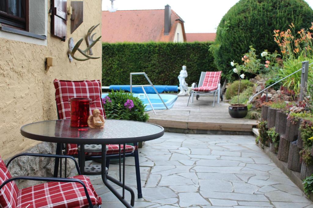 a patio with a table and chairs in a yard at Altes Forsthaus in Gebsattel