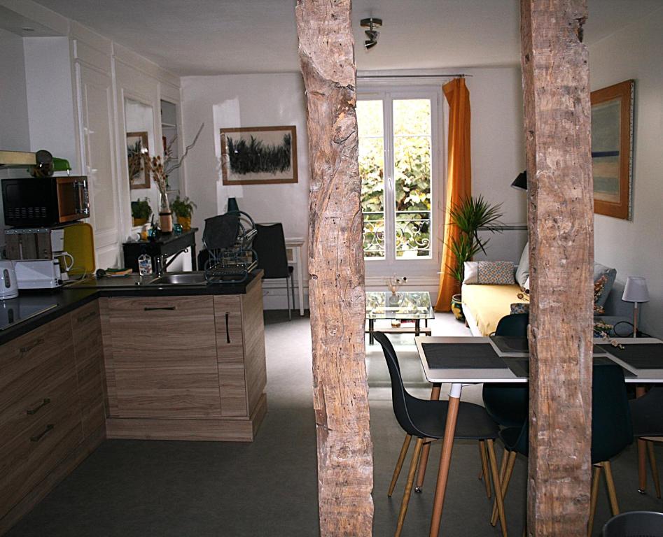 a room with a kitchen and a table with chairs at Le Libération in Limoges