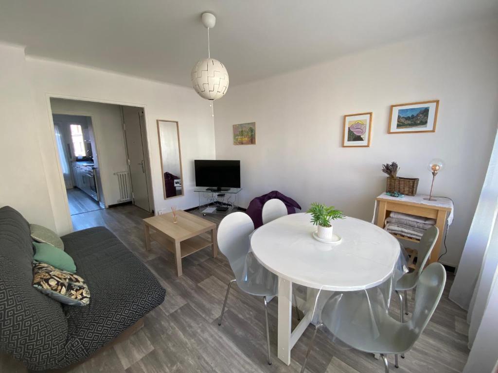 a living room with a white table and a couch at Bel Appartement Residence Mirabeau in Aix-en-Provence