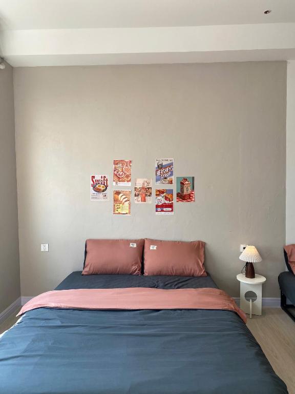 a bedroom with a bed with posters on the wall at Phieu Brew Homestay in Hà Tiên