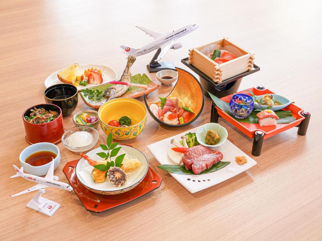 a table topped with plates of food and a toy airplane at さめうら荘レイクサイドホテル in Tosa