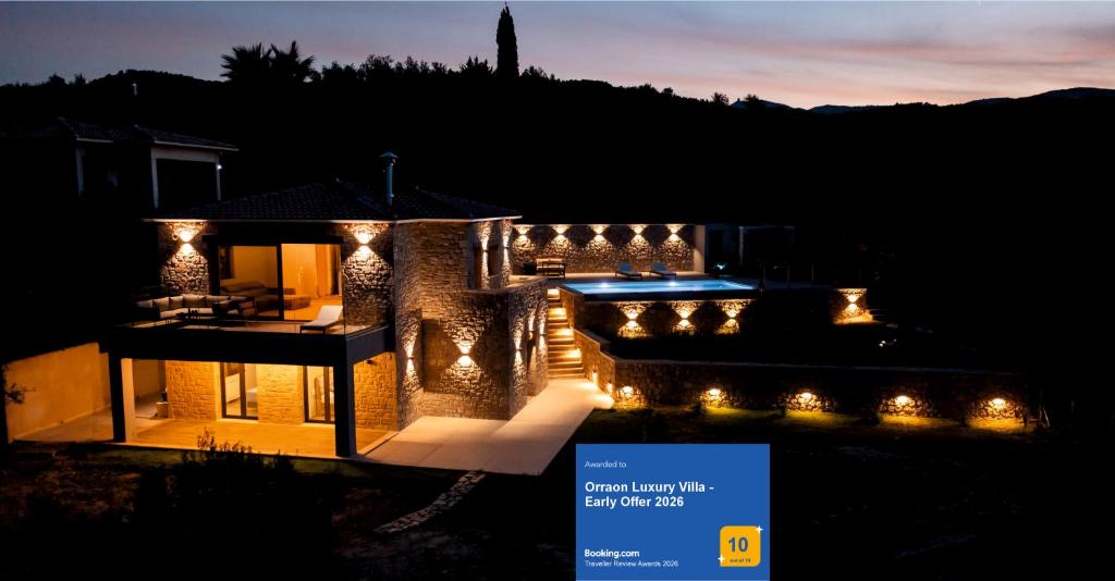 a house lit up at night with lights at Orraon Luxury Villa - Exclusive retreat with panoramic views and infinity pool in Lefkada
