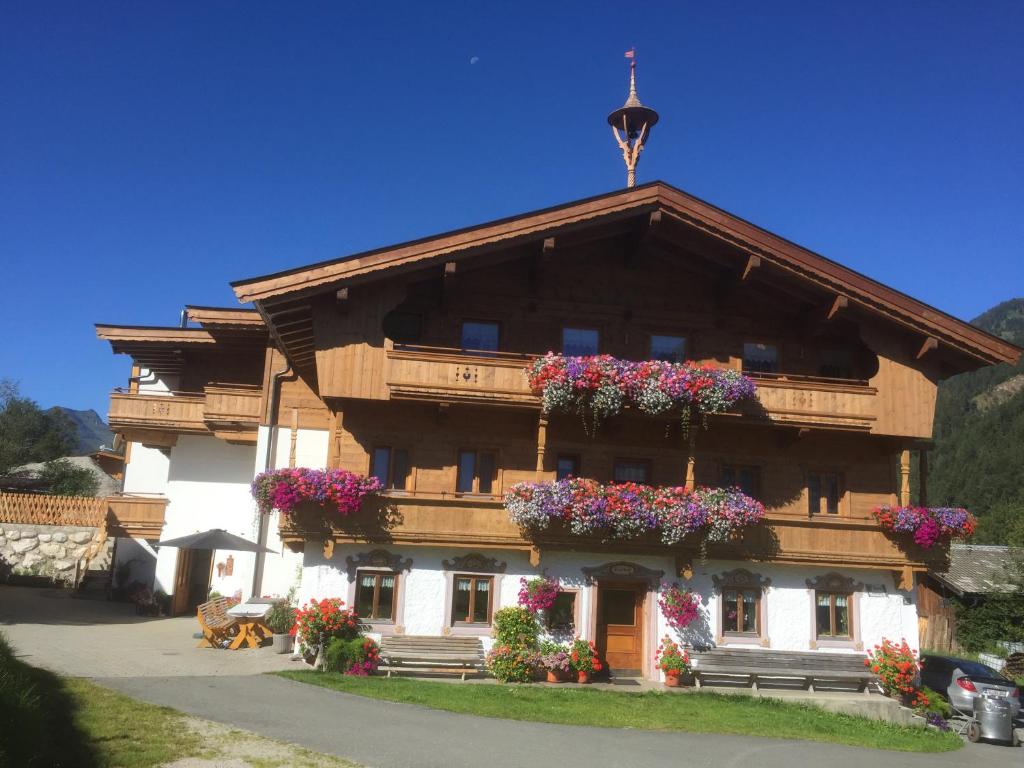 ein Gebäude mit Blumen auf der Vorderseite in der Unterkunft Trixlhof in Sankt Ulrich am Pillersee