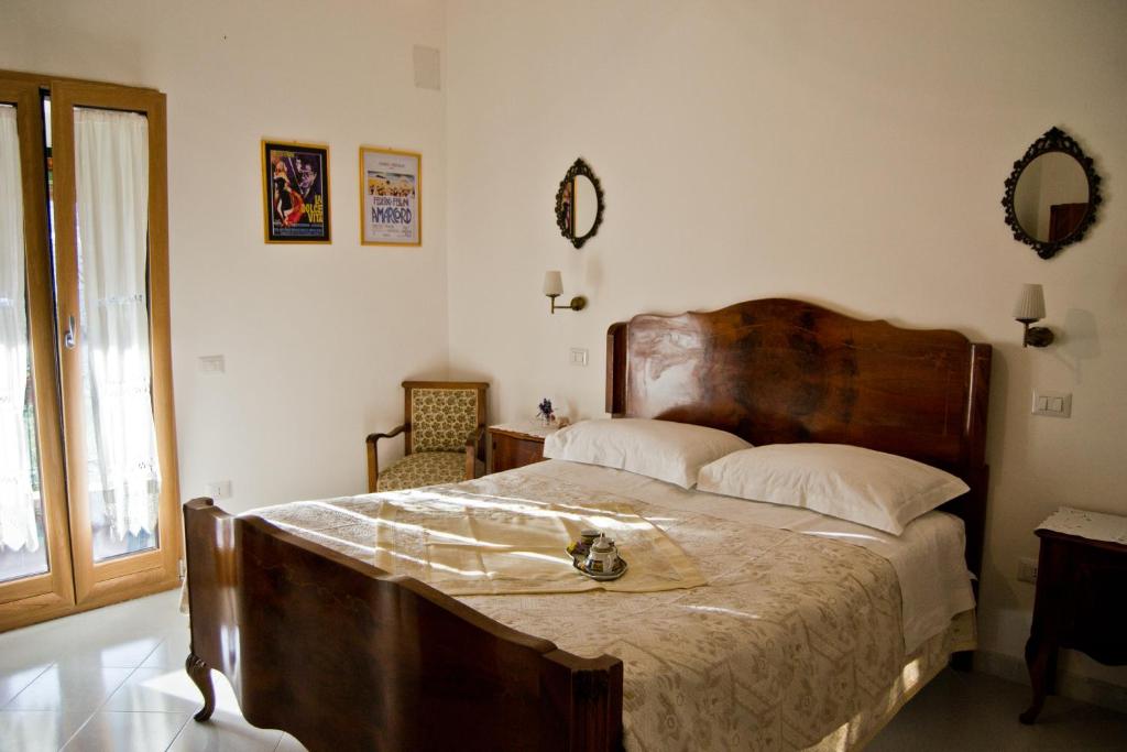 a bedroom with a large bed with a wooden headboard at La piccola casa del cinema in Giffoni Valle Piana