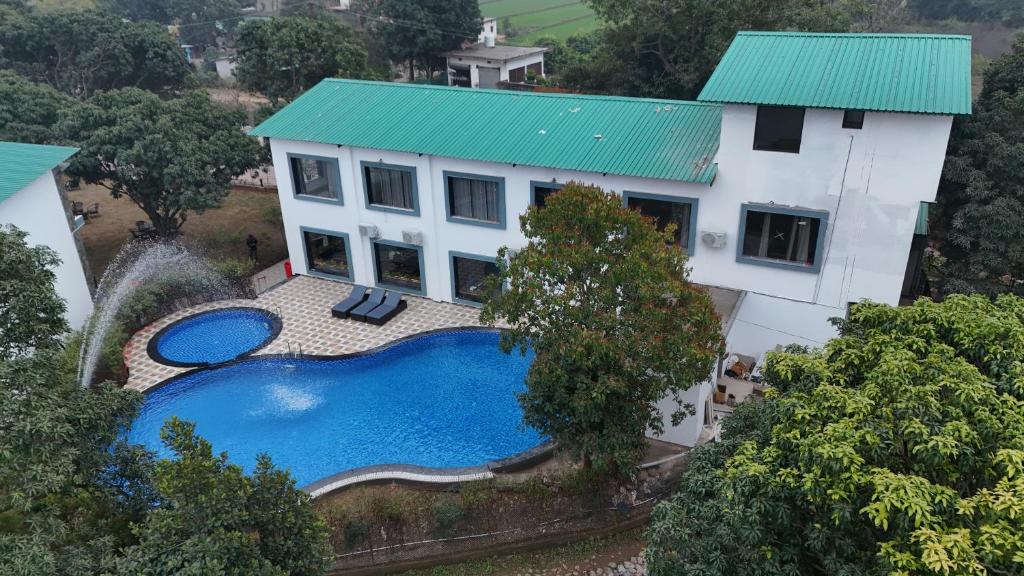 an aerial view of a house with a swimming pool at Wonderwood Corbett Resort -1min walk to River with Deep Jungle Trail in Rāmnagar