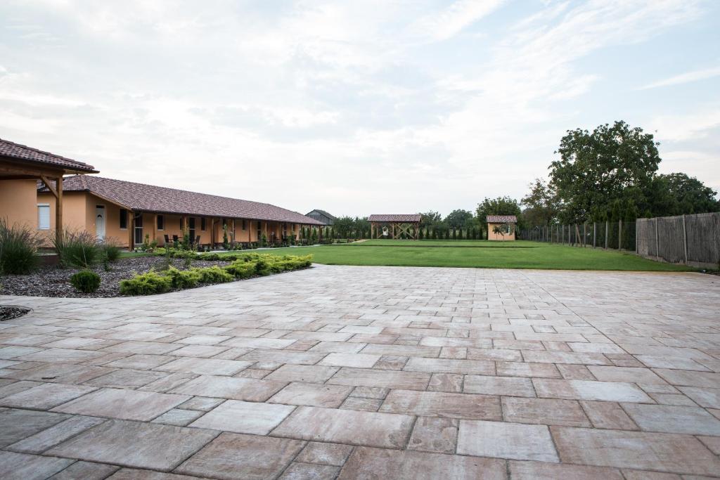 a stone driveway in a yard with a fence at Relax Apartmanház in Mórahalom