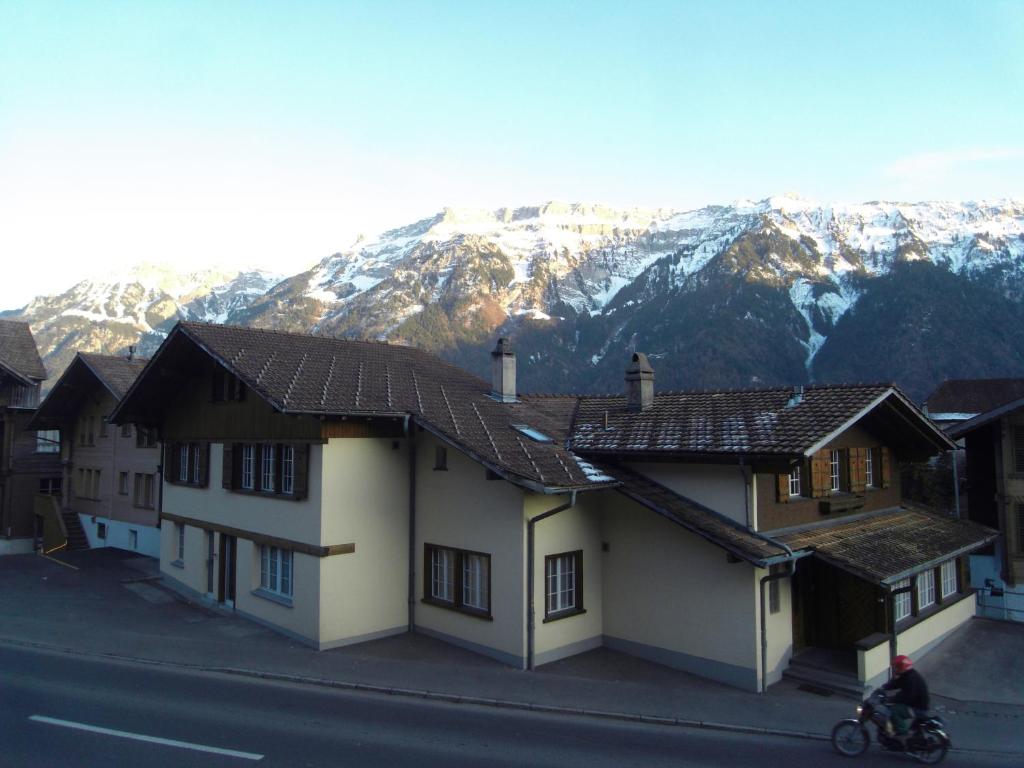 Un grupo de casas con montañas al fondo en Royal Swiss Apartments, en Ringgenberg