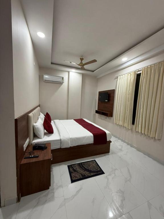 a hotel room with a bed and a television at Aureva Kamla Heritage in Jaipur