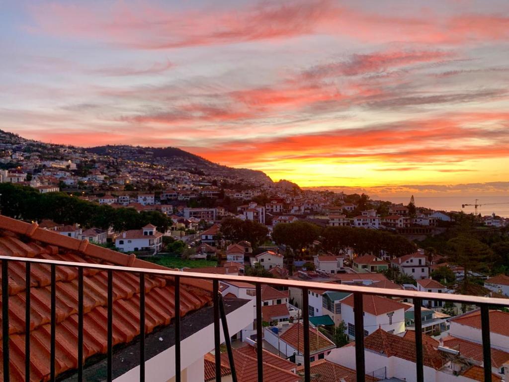 a view of a city at sunset from a balcony at Residencial do Vale in Funchal