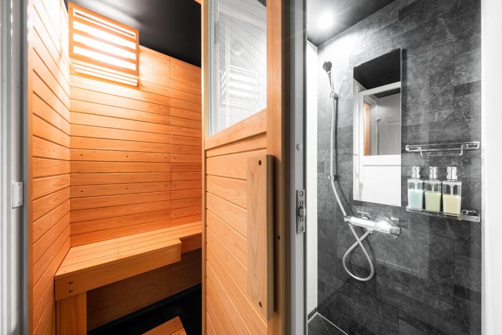 a walk in shower in a bathroom with wood at The Elements in Nakafurano