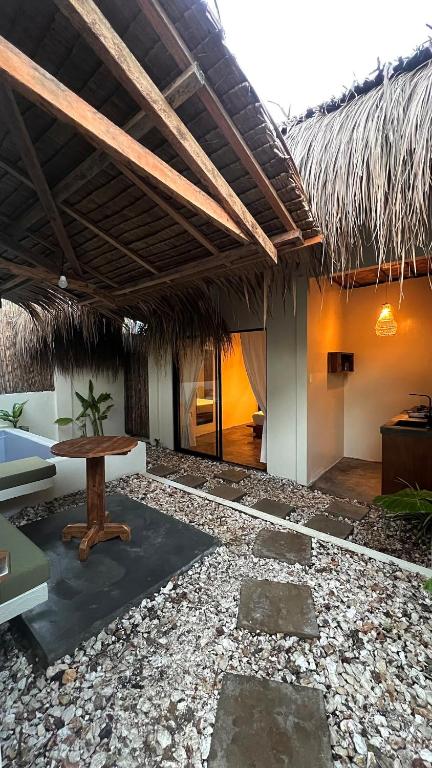 a room with a table and a straw roof at Ginhawa Stay Private Pool Studio in Burgos