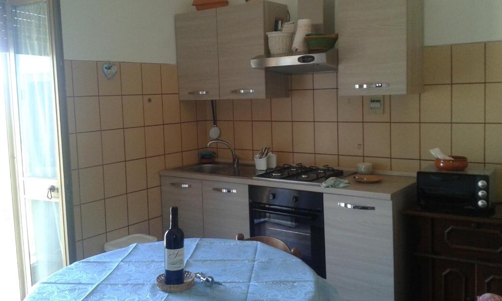 a bottle of wine sitting on a table in a kitchen at Casetta Galassi in Cinigiano