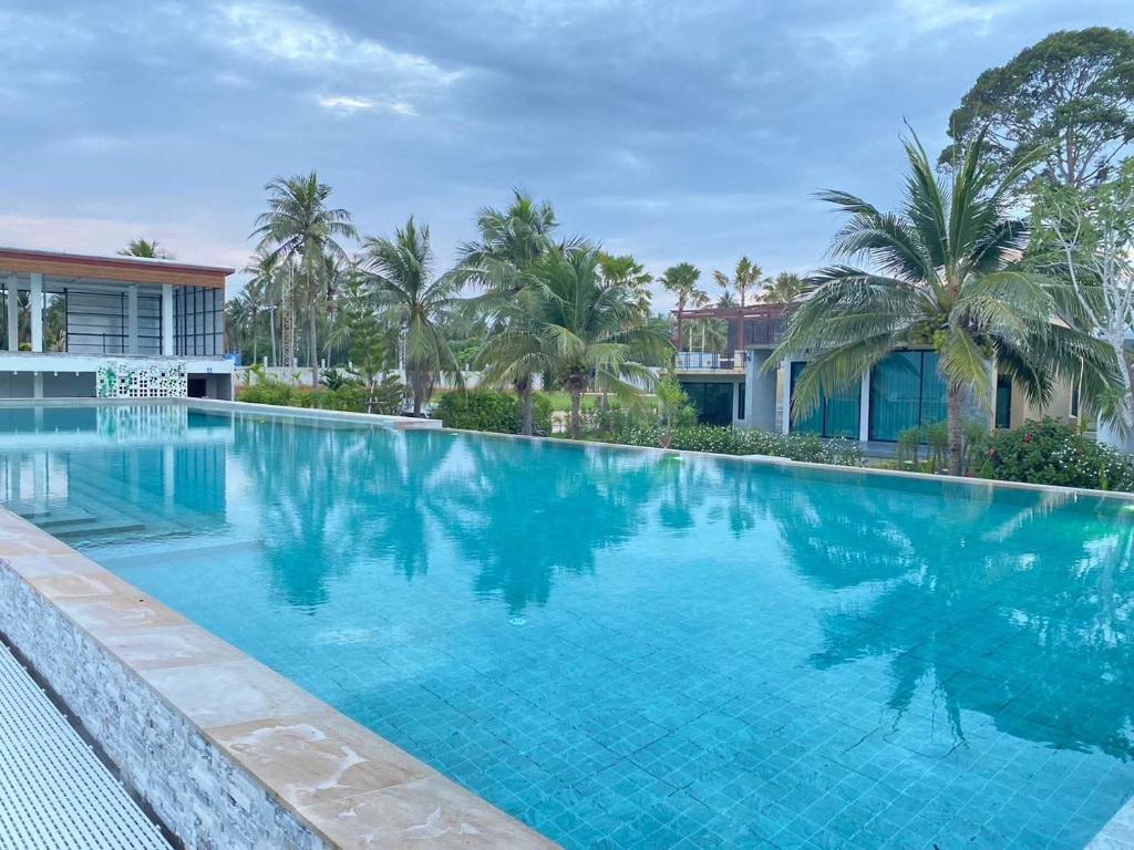 a large swimming pool in front of a resort at F&F Poolvilla Beach Tha Chana in Suratthani