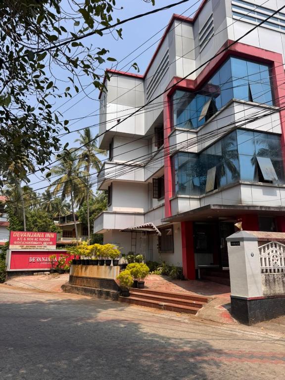 a tall building withwindows and plants in front of it at devanjana Guruvayur in Jāmb