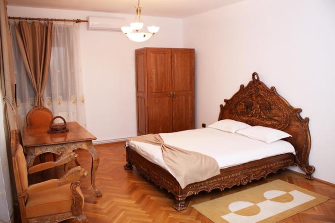 クラヨーヴァにあるCasa Craiova Nuovaのベッドルーム(大型ベッド1台、木製テーブル付)