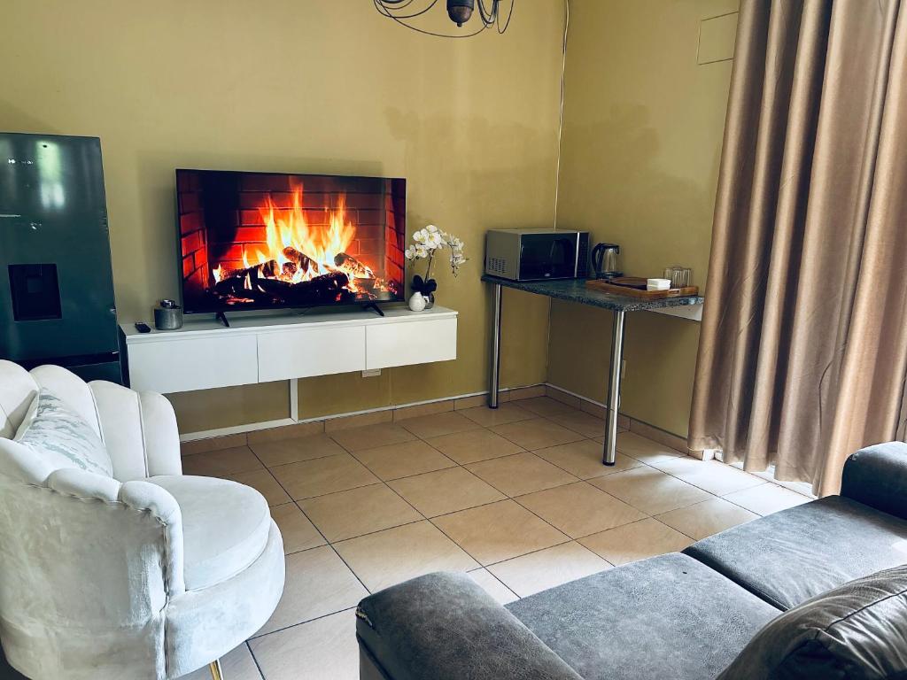 a living room with a fire in a fireplace at Koshoka Suites in Ongwediva