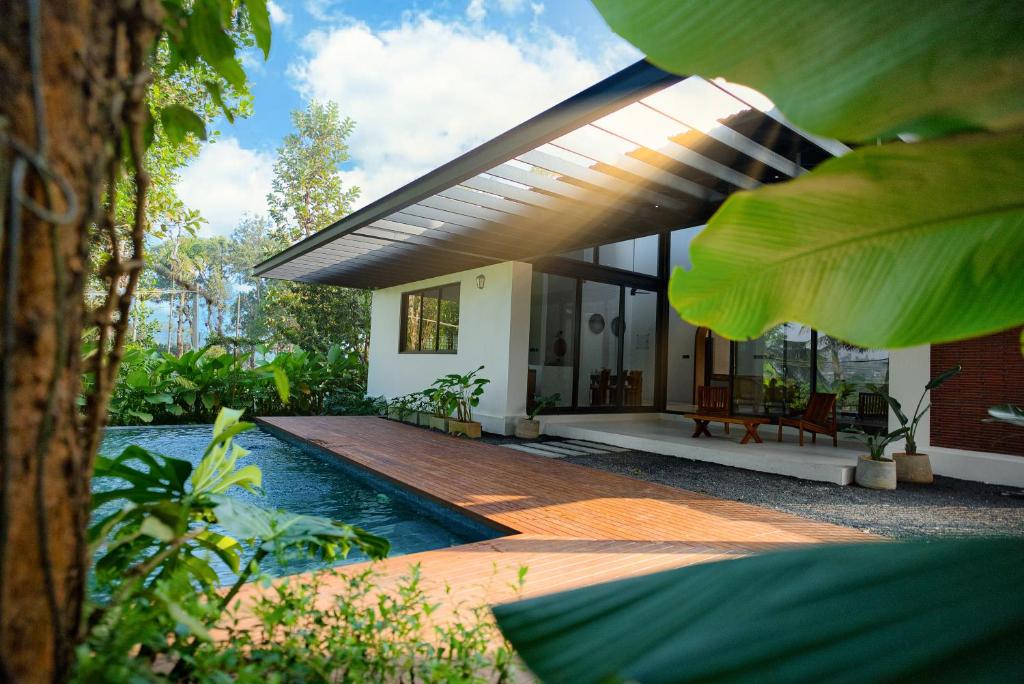 a house with a swimming pool in front of it at The Villa - Premium Private Pool Villa in Vaduvanchal