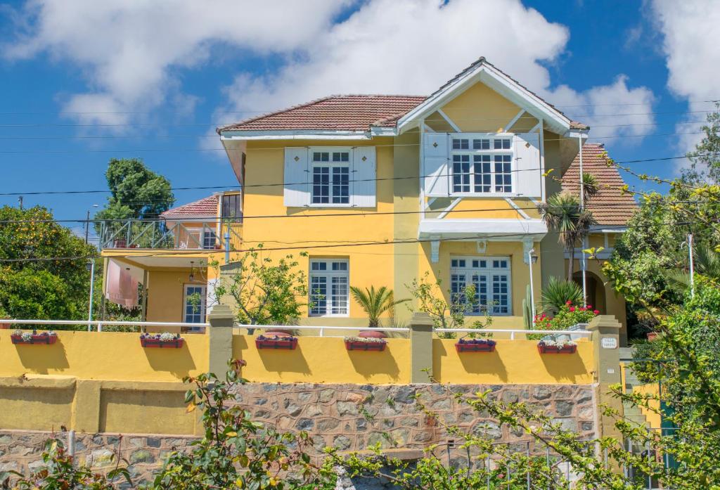 a yellow house with a fence at Pontoval B&B in Valparaíso