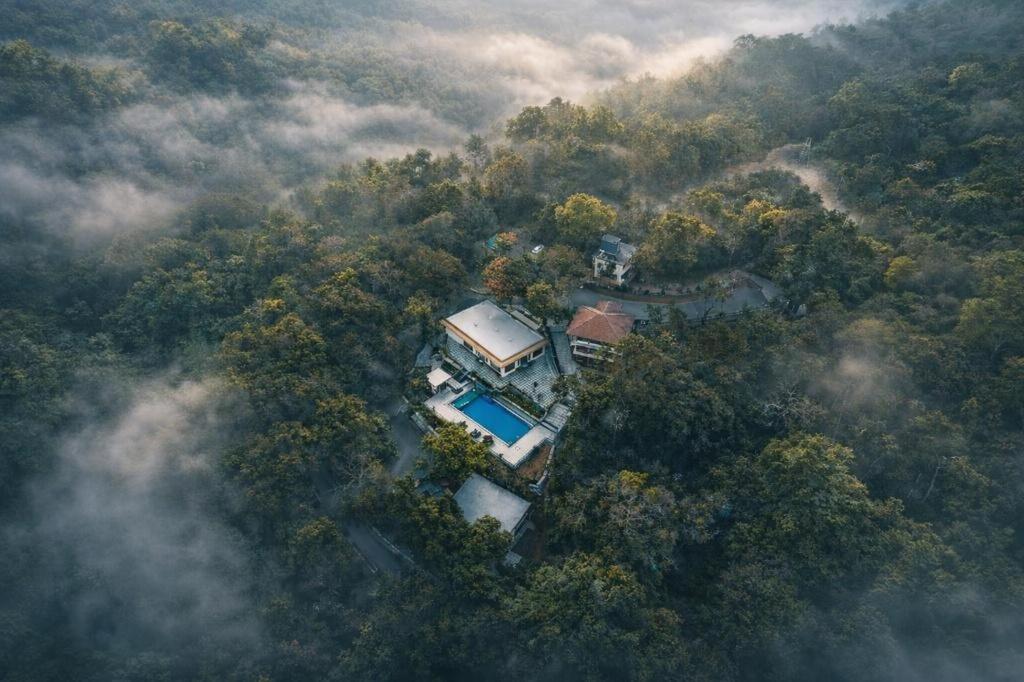 an aerial view of a house in the middle of a forest at Nirjhara Coorg in Somvārpet