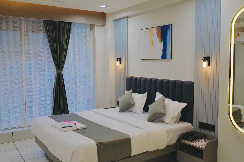 a bedroom with a bed and a window at Hotel Palash Icon in Ahmedabad