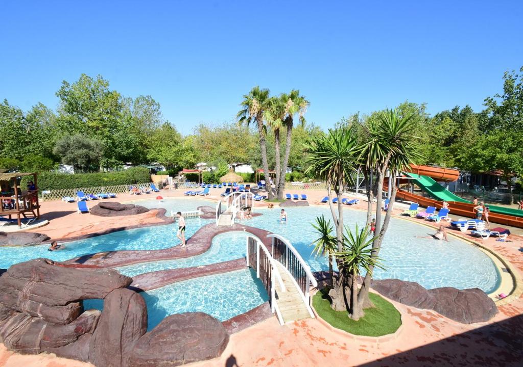 a pool at a resort with people in it at Camping Les Salisses - Aquatique Vacances in Vias