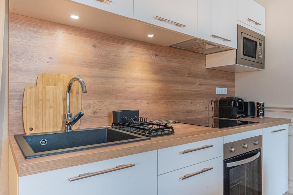a kitchen with a sink and a counter top at Le Chic, en hypercentre au calme in Limoges