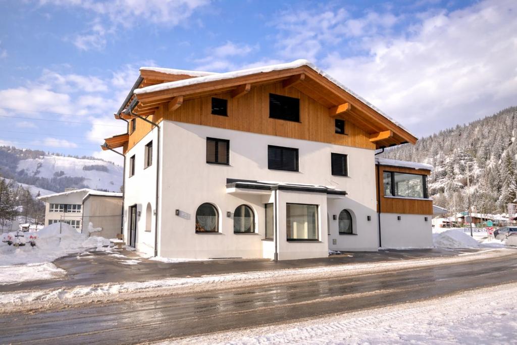 a large white building with a wooden roof at Staminé in Hochfilzen