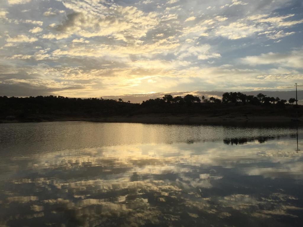 a view of a lake with clouds in the water at Herdade do Gamito in Crato