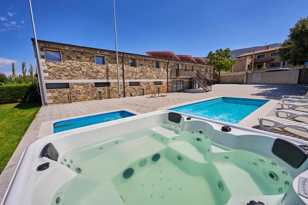 a hot tub on a patio next to a building at Villa Meraki experiencia in San Miguel de Corneja