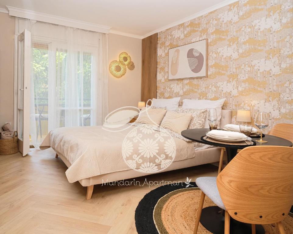 a bedroom with a bed and a table at Mandarin Apartment in Harkány