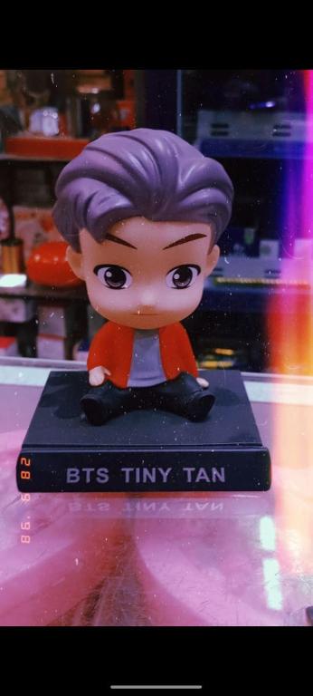 a toy figurine with purple hair sitting on a table at Royal Ambience in Jāmb