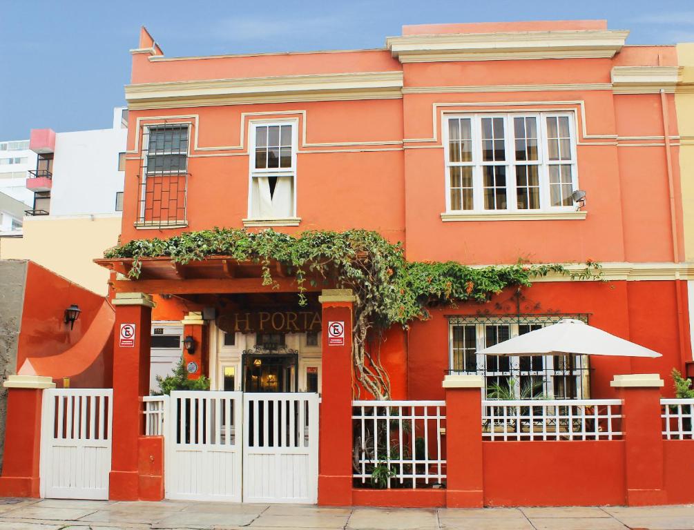 un edificio naranja con una valla blanca delante de él en Casa Porta, en Lima