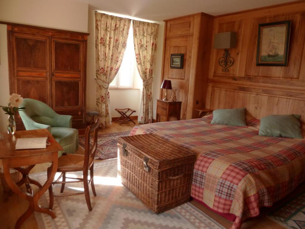 ボズールにあるChambres d'Hôtes du Hameau Les Brunesのベッドルーム1室(ベッド1台、テーブル、椅子付)