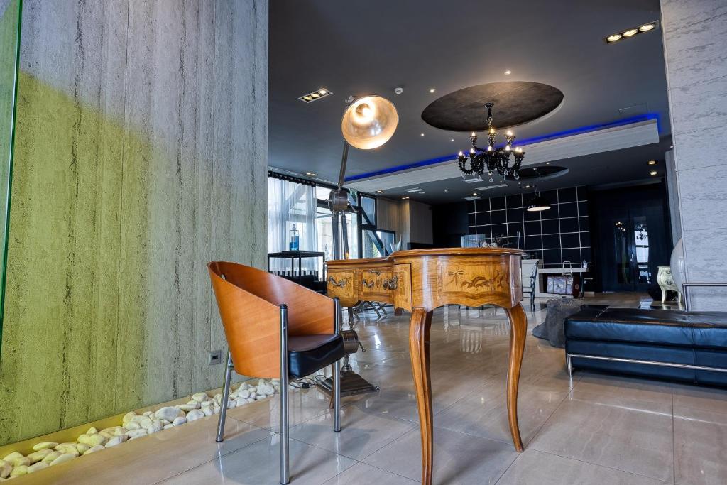 a dining room with a wooden table and chairs at Gallery Art Hotel in Tríkala